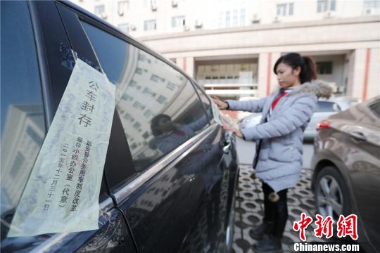 圖為工作人員給公務(wù)用車(chē)貼封條�！∽T凱興　攝